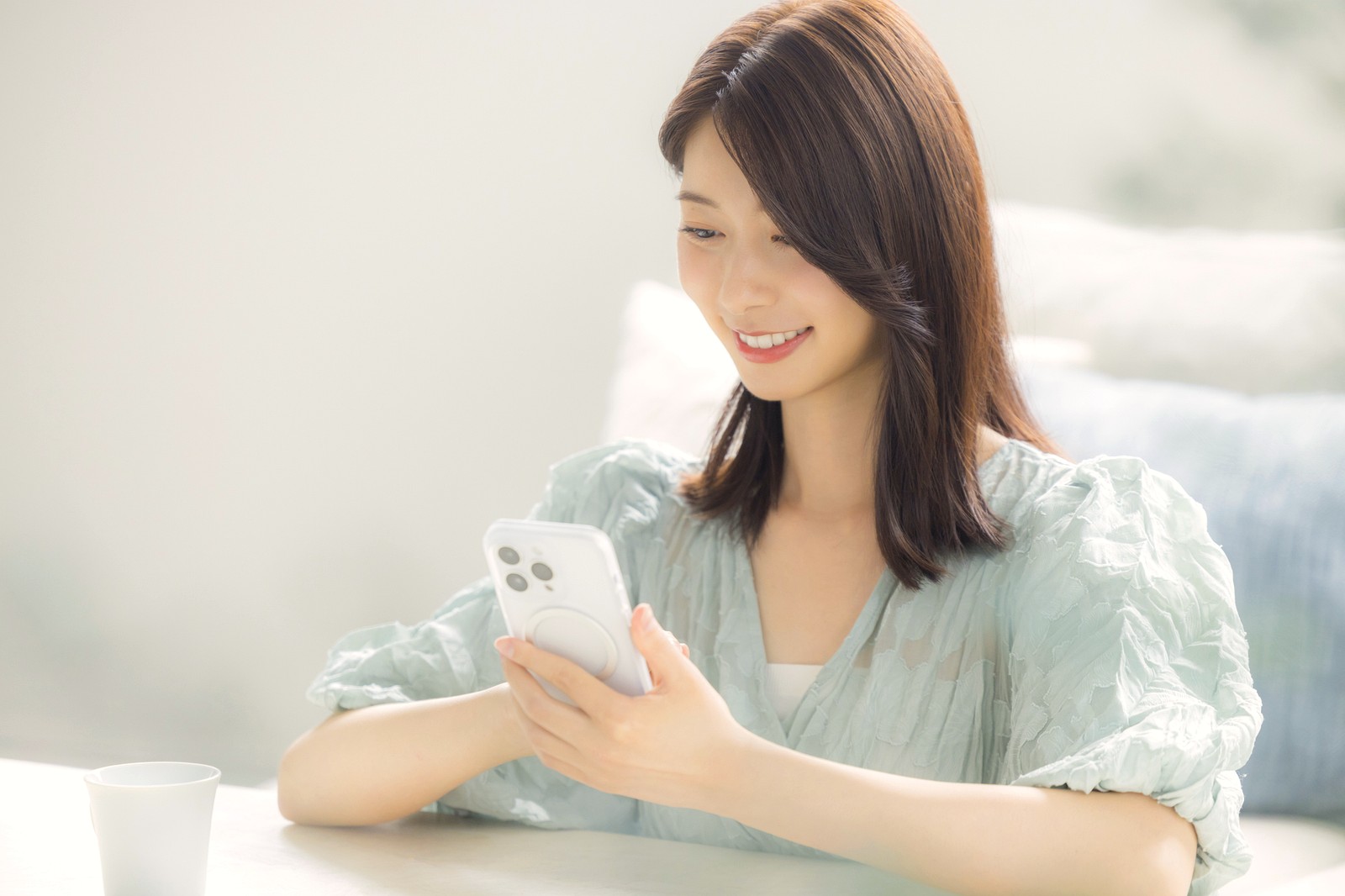 出発前に自宅のスマートフォンで下調べをする女性