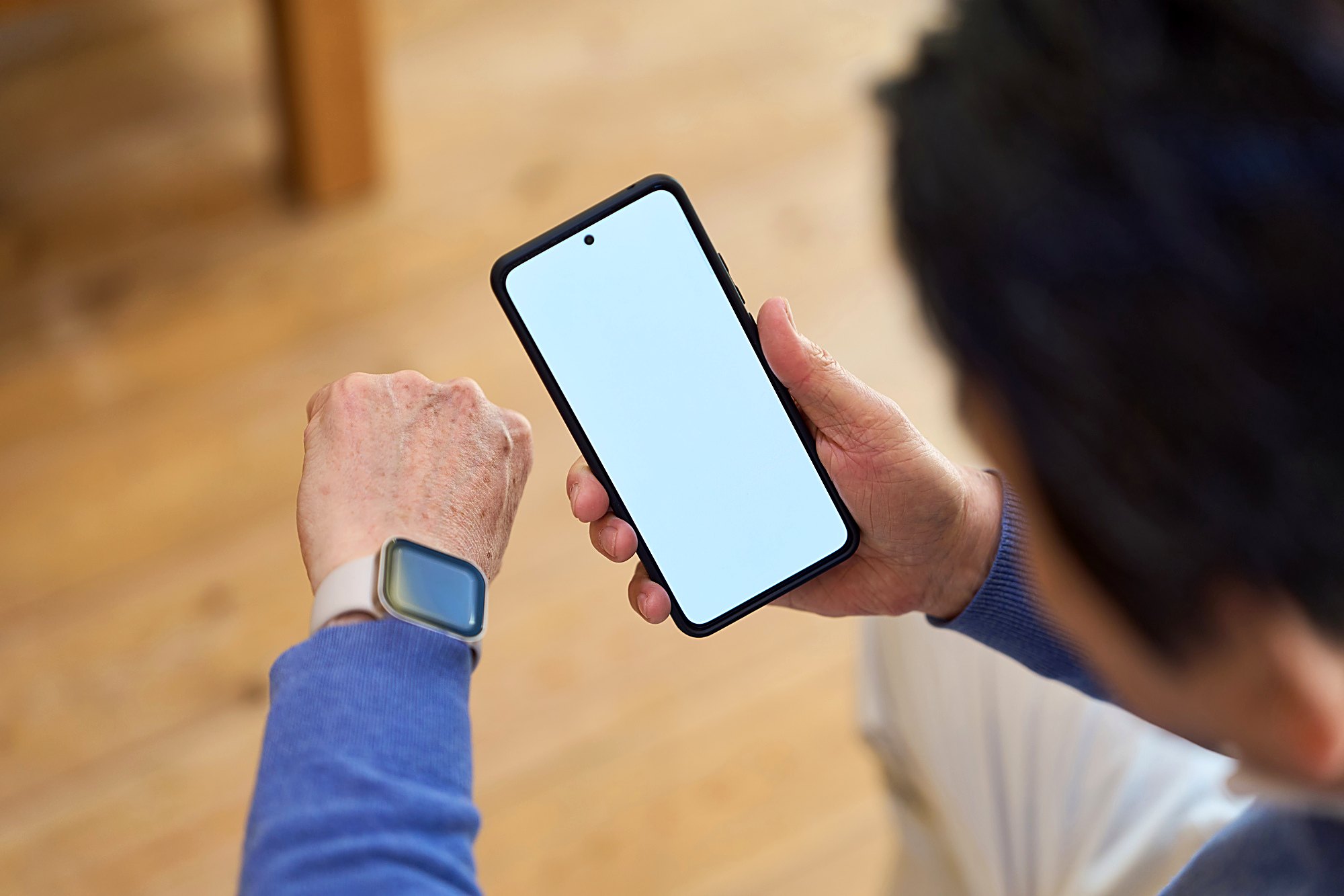 実家で家族が一緒にスマートフォンの画面を見ている様子