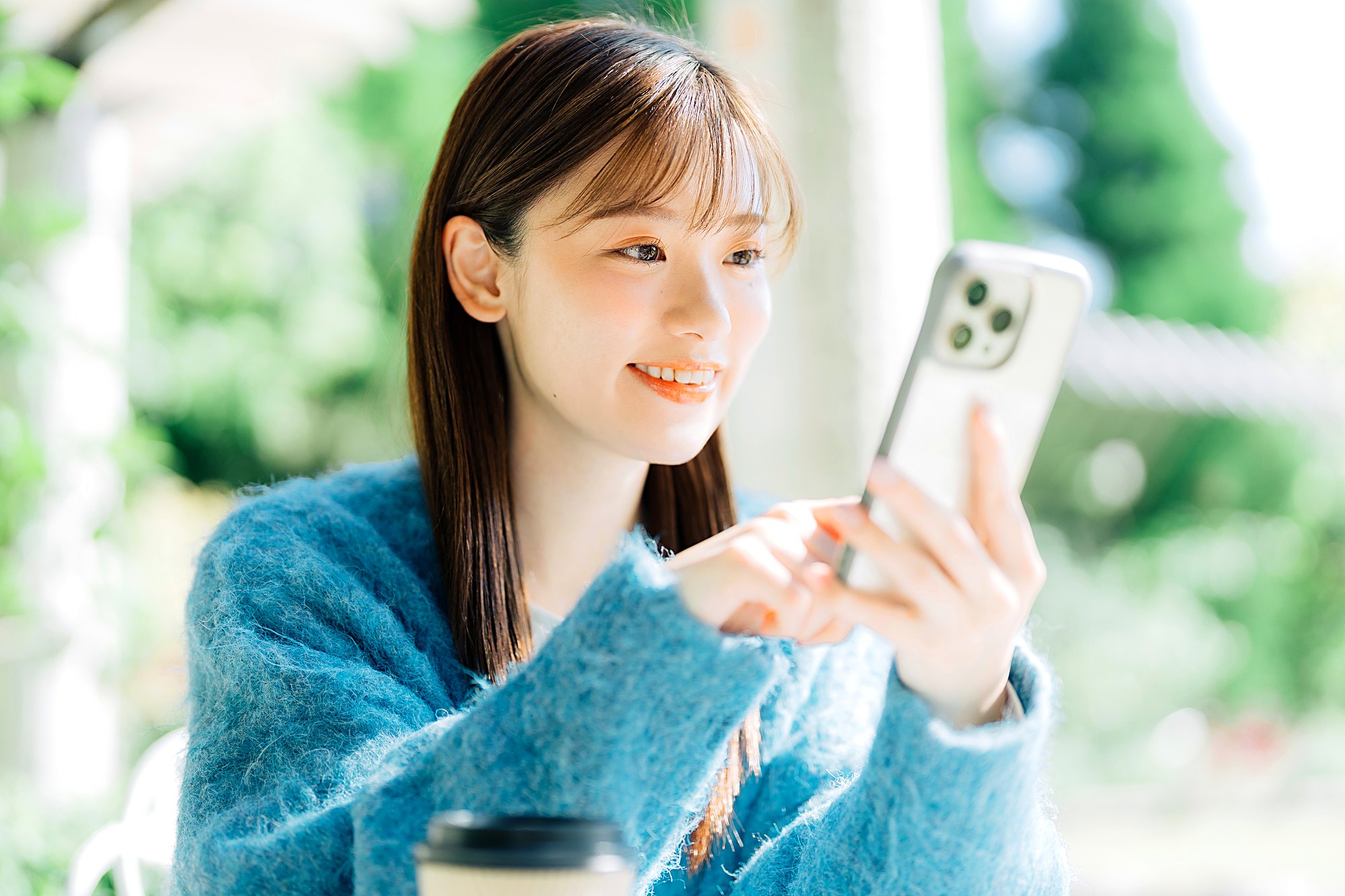 外出先でスマートフォンを見ながら情報を確認する様子