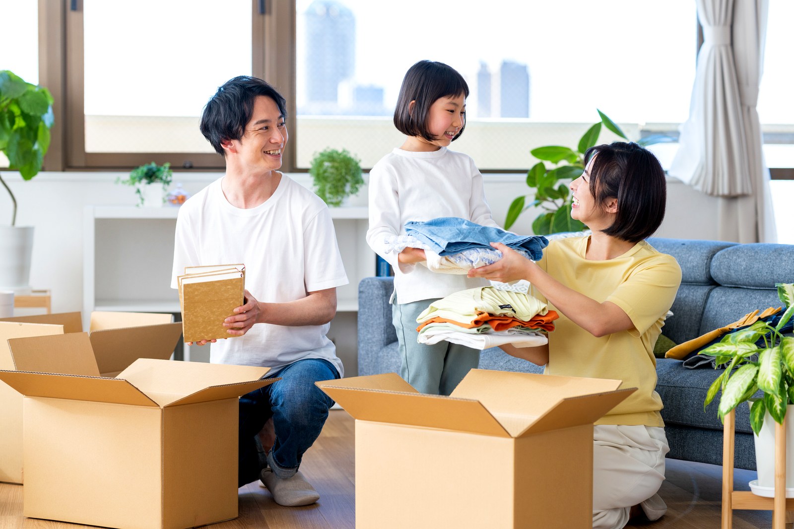 引越しの荷造りをする若い家族