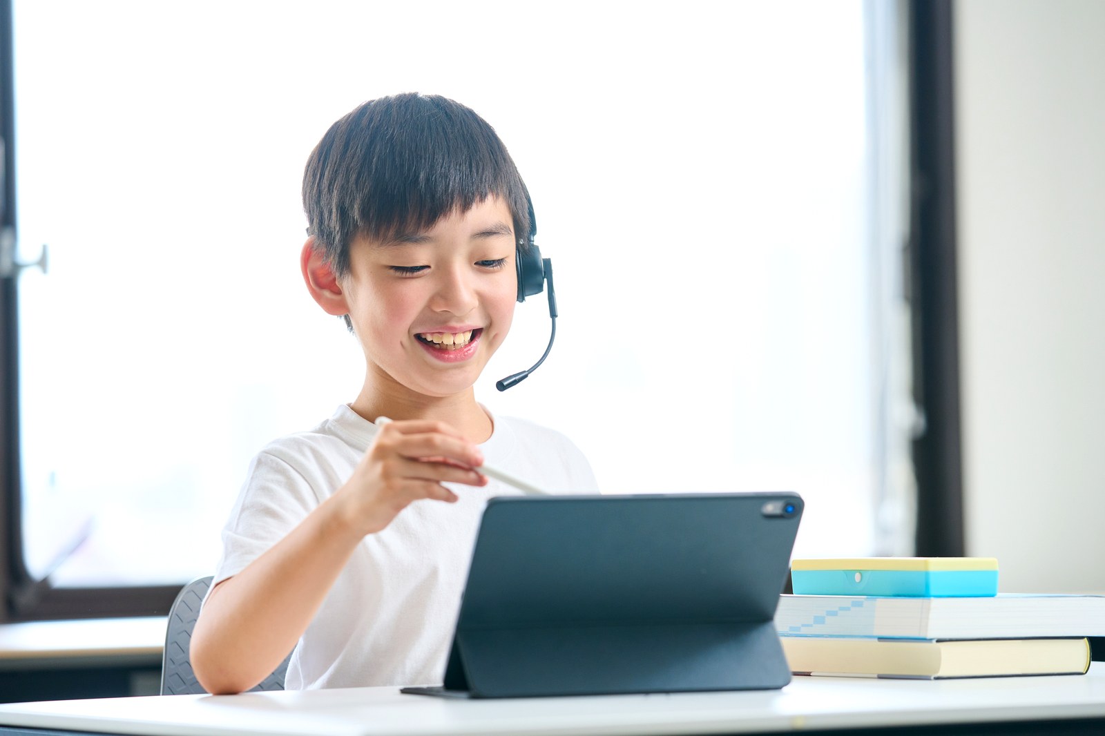 ヘッドセットでオンライン授業を受ける小学生