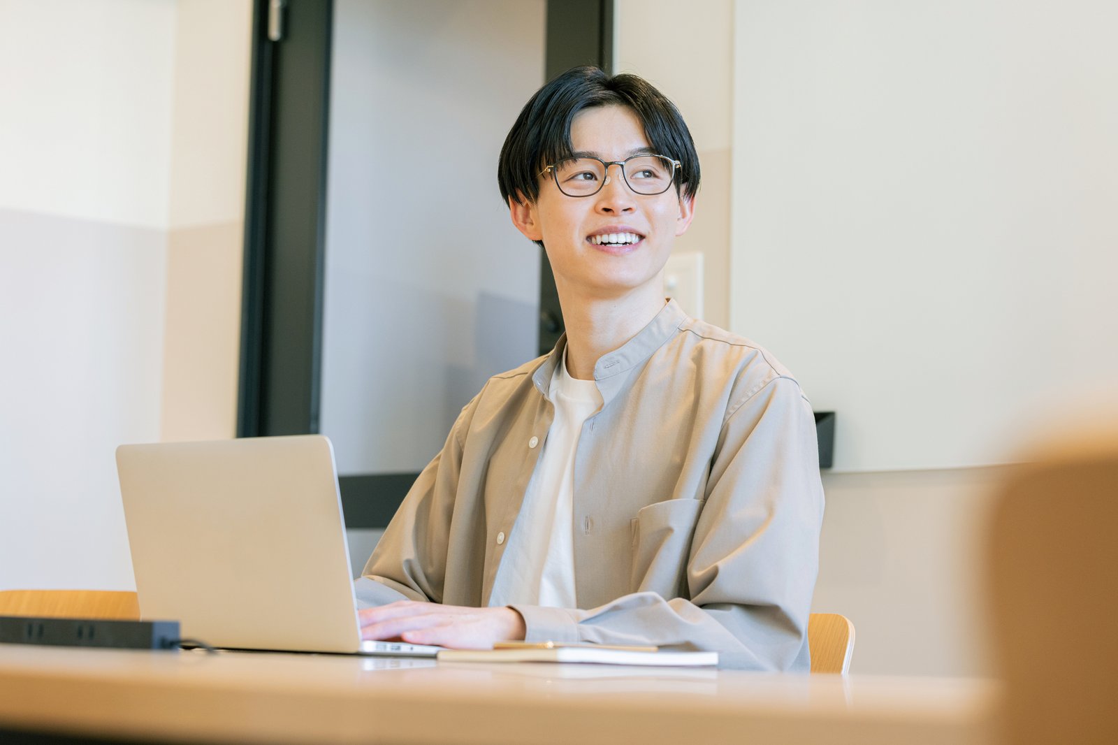 カフェでノートパソコンを開いて仕事をする男性
