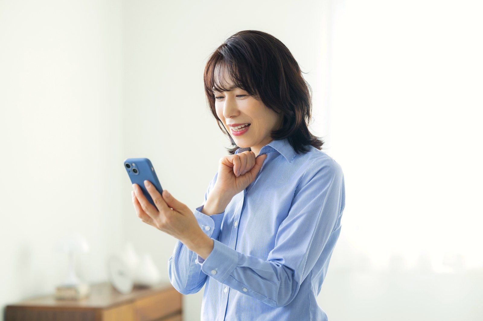 リビングでスマホを使う女性