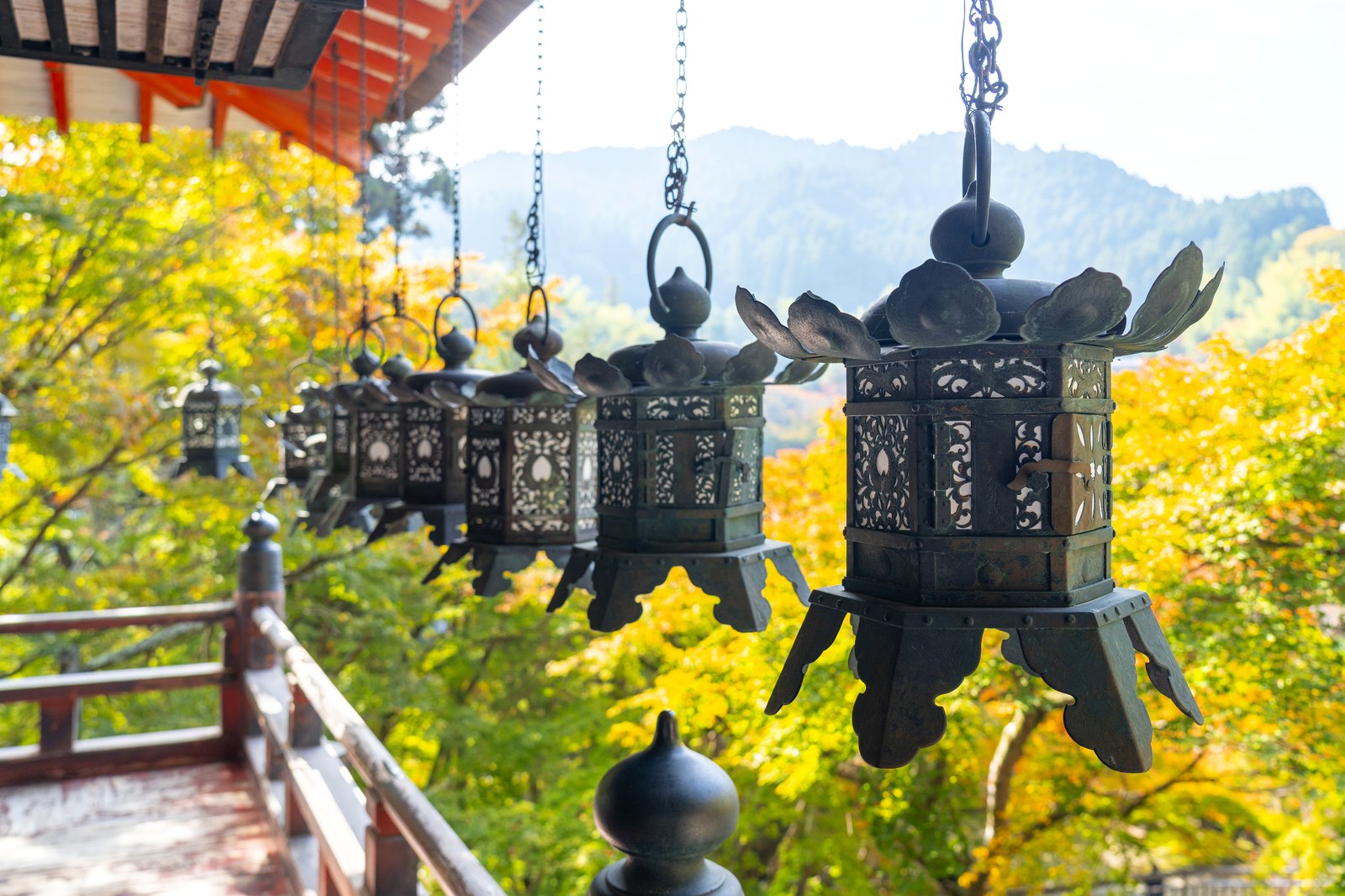 談山神社の軒下に連なる釣燈籠と、色づきはじめた山並み