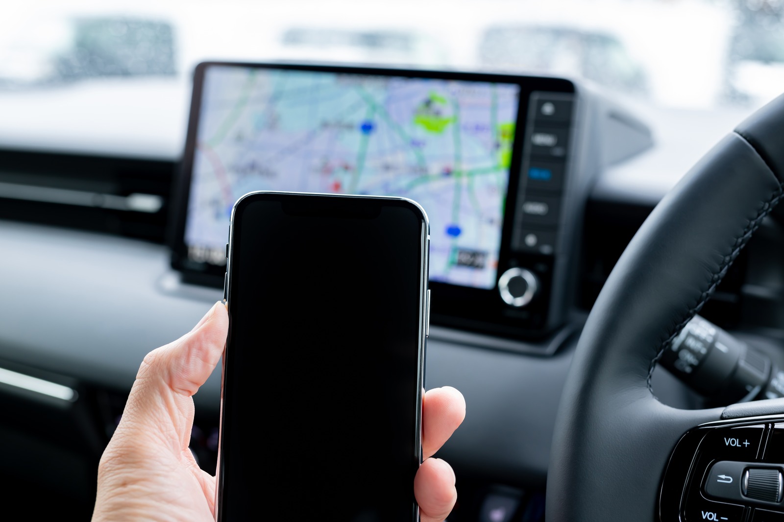 車内でカーナビとスマートフォンを見る手元