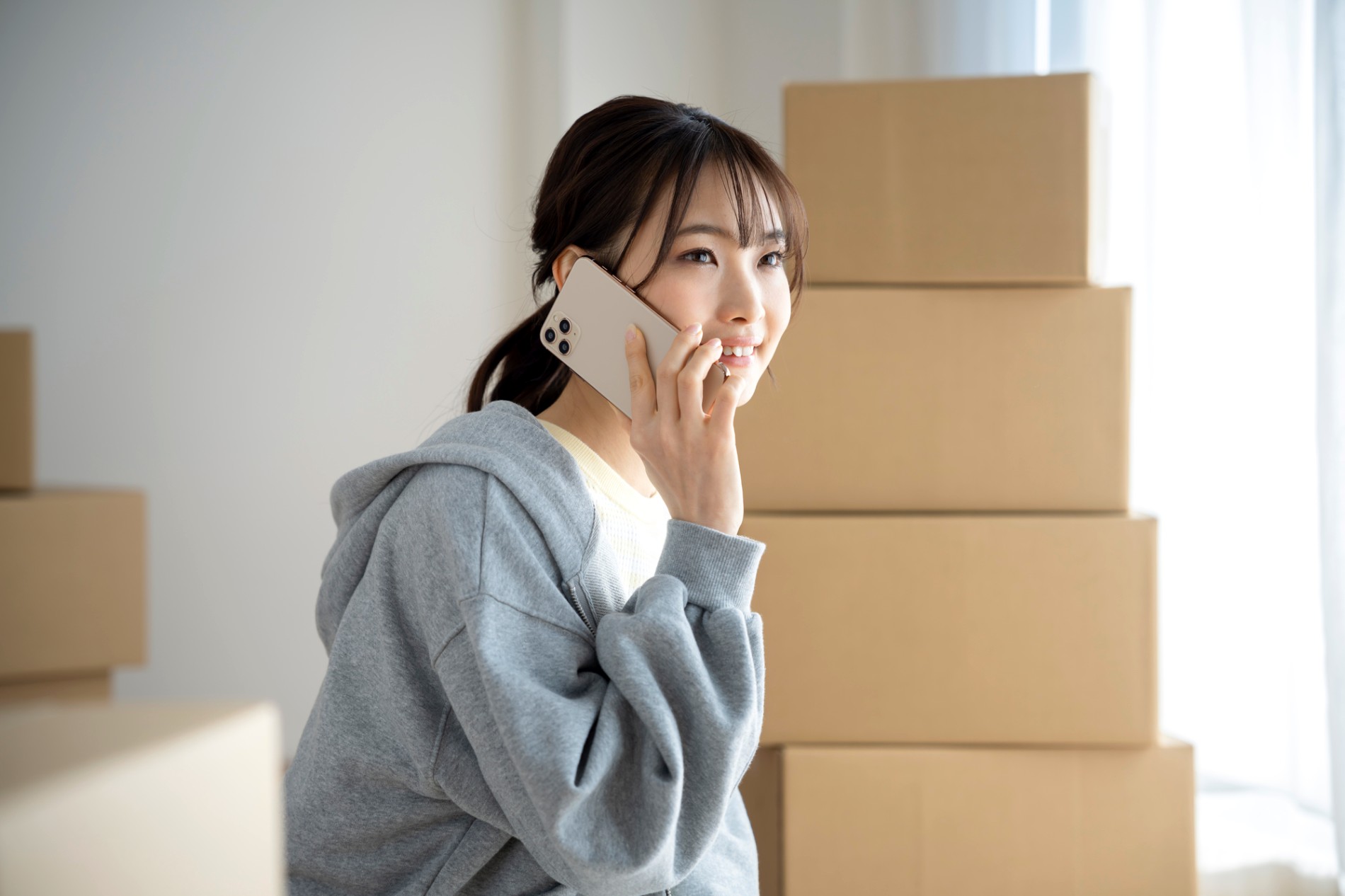 荷物を運び入れた部屋でスマートフォンを使って連絡をとっているところ