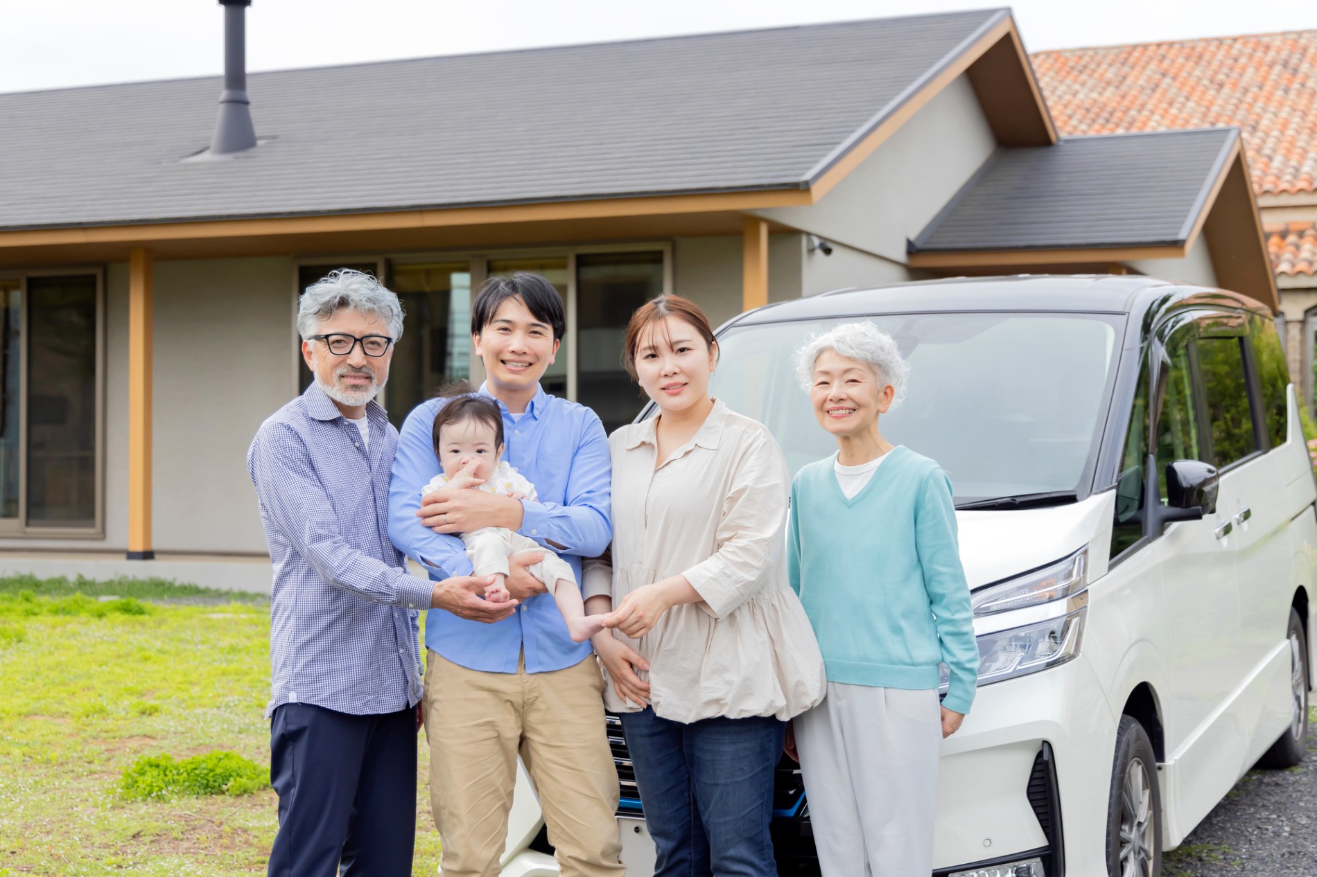 車で出かける支度をしている三世代の家族