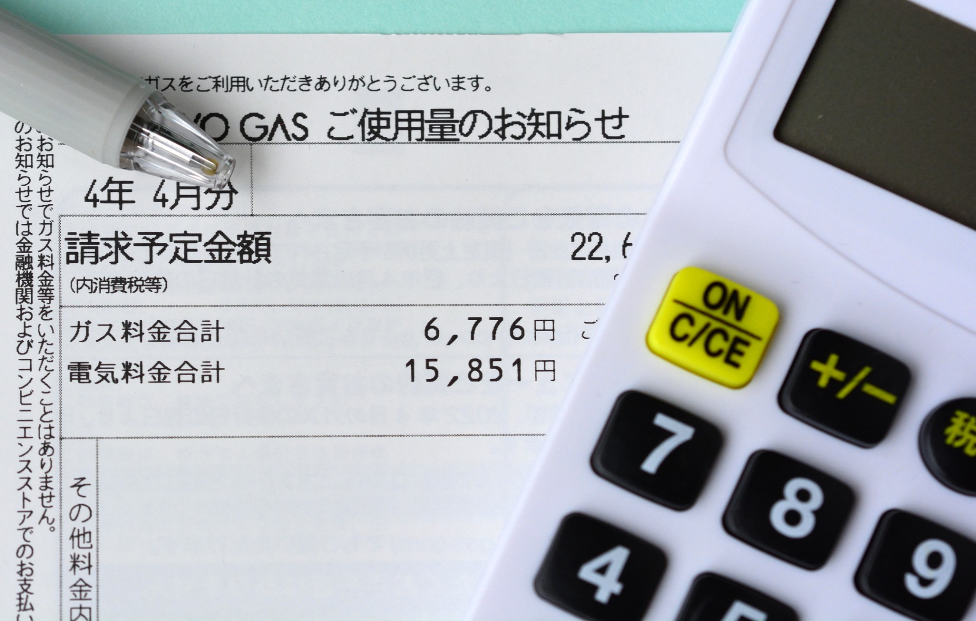 使用料金の明細書と電卓を並べて計算しているところ