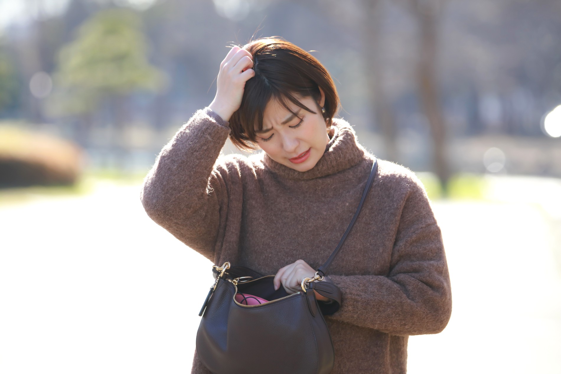 外出先で持ち物が無いことに気づいて鞄を探す人