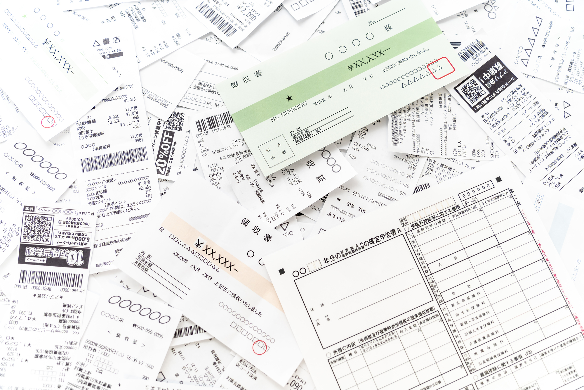 確定申告書と、積み上がったレシート・領収書