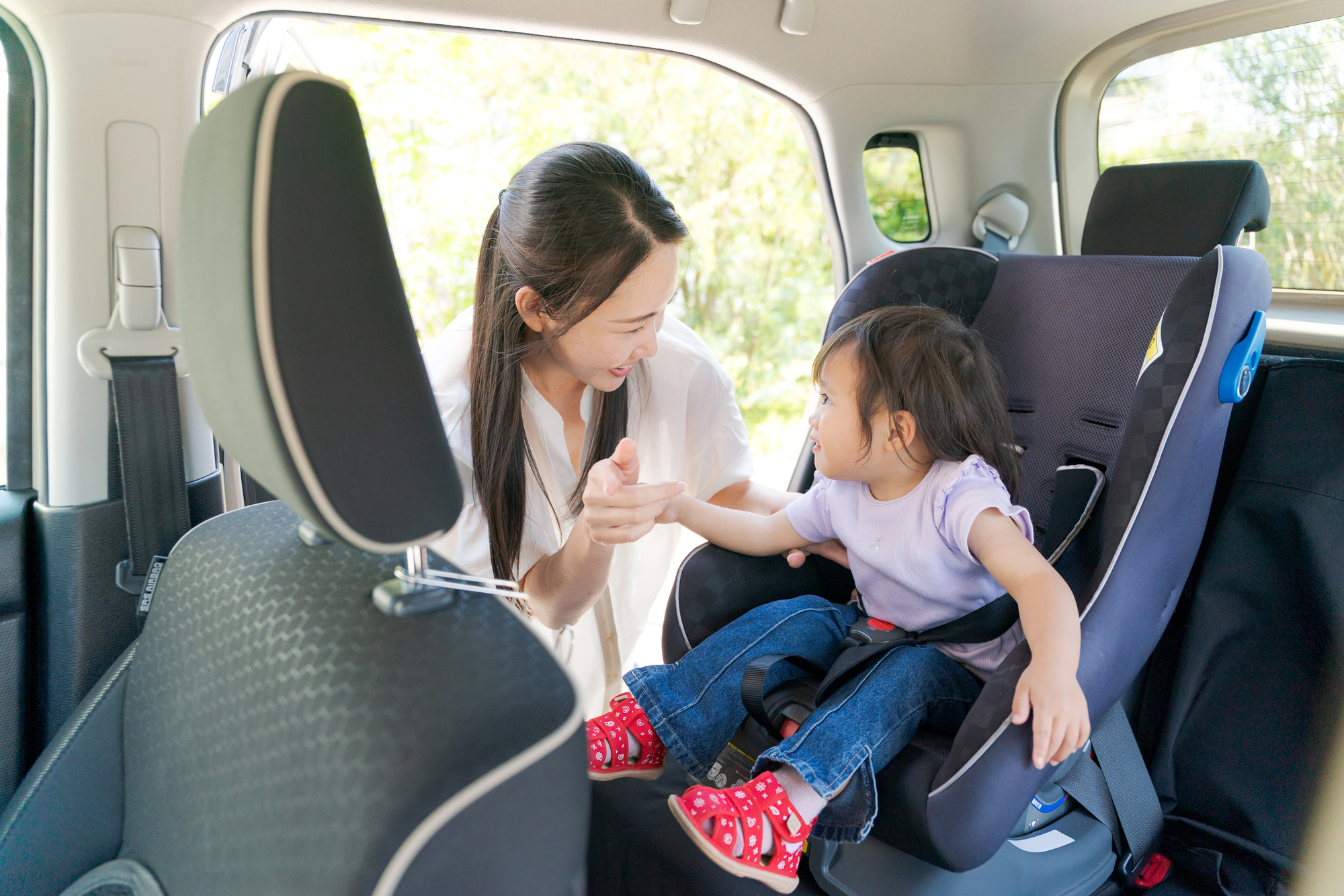 車に子どもを乗せる保護者の様子