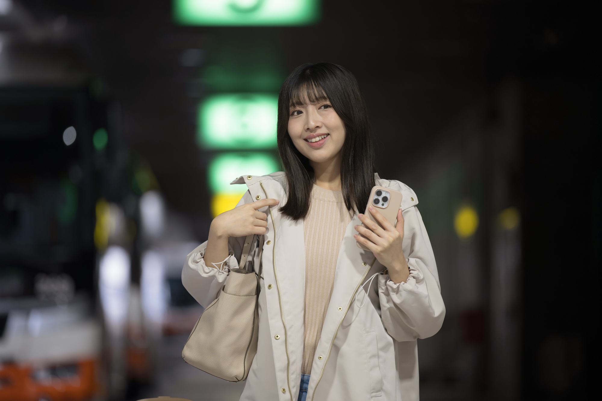 夜の駅でスマートフォンを持つ人