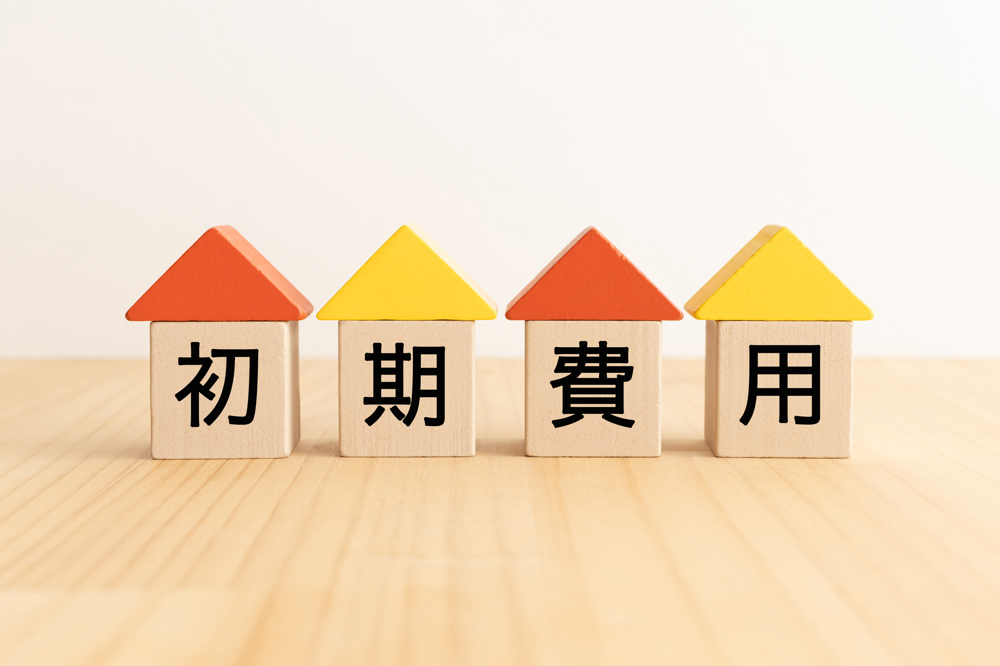 初期費用という文字が一字ずつ入った、家の形の積み木