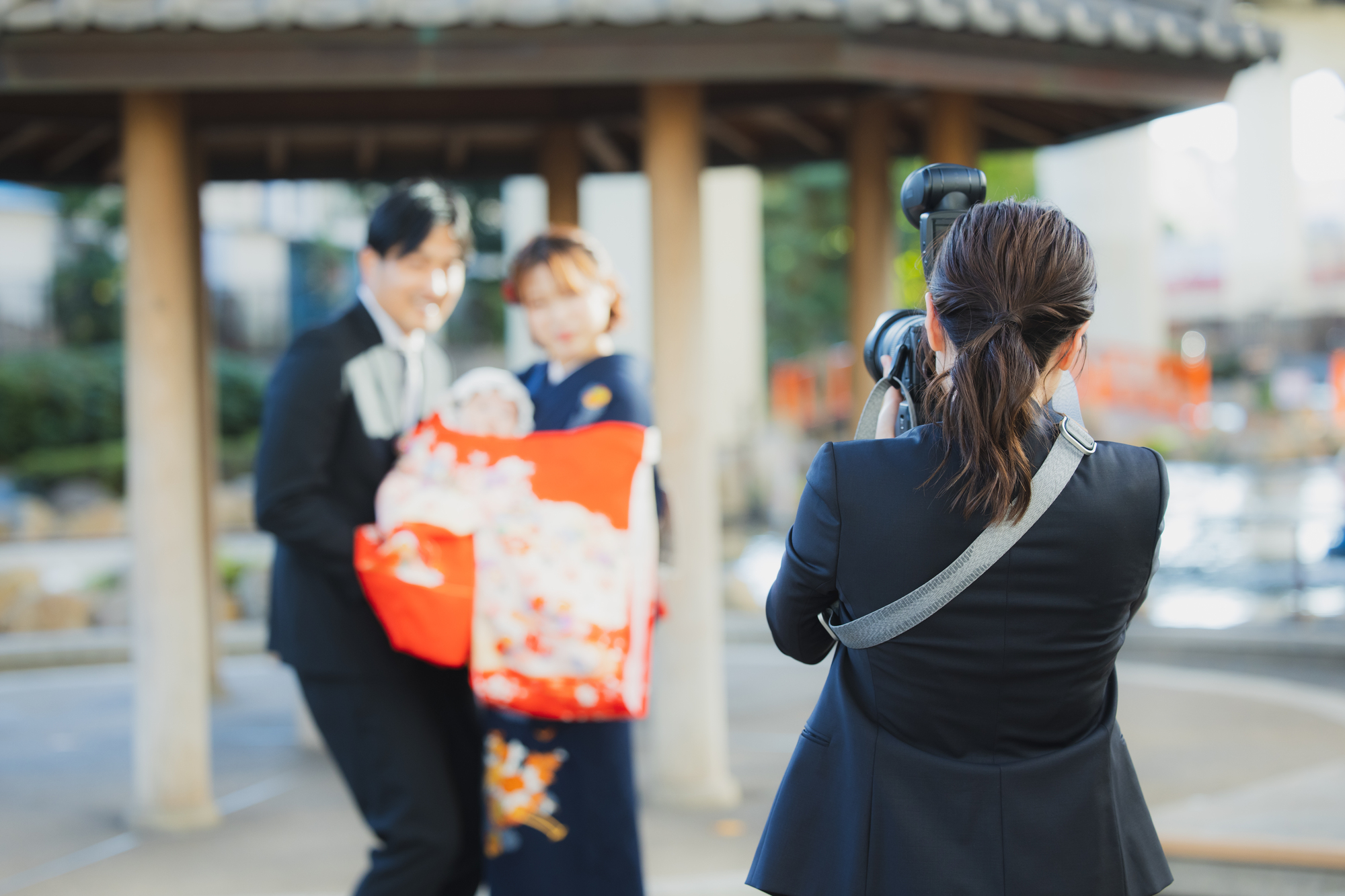 屋外で家族の記念写真を撮る出張カメラマン