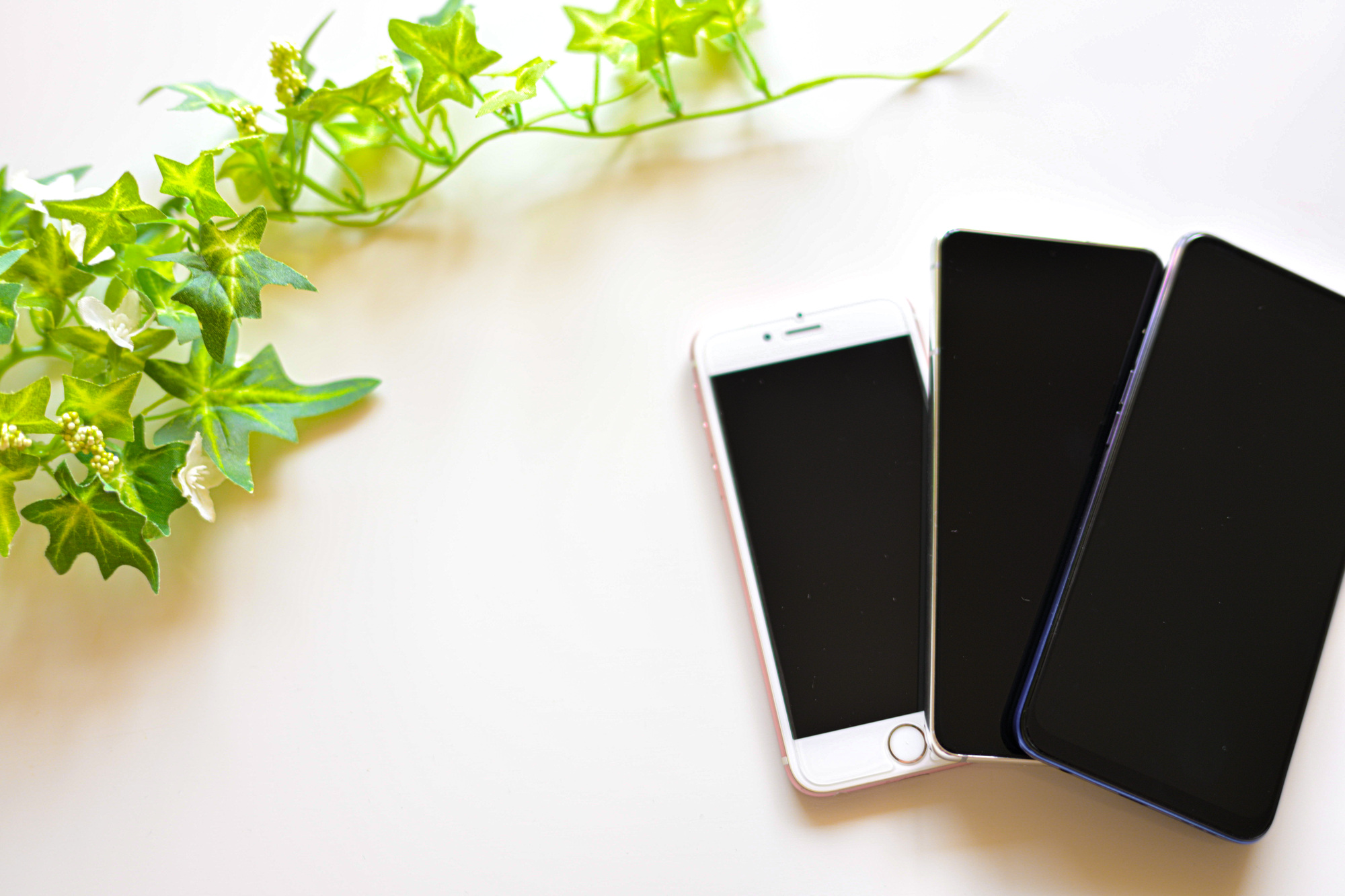 白い机に並べた複数のスマートフォン