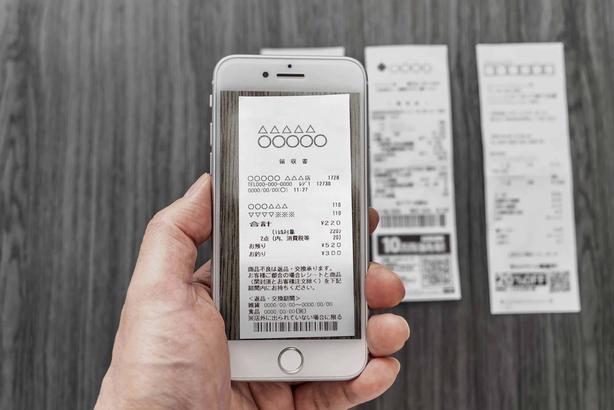 スマートフォンでレシートを読み取っている手元