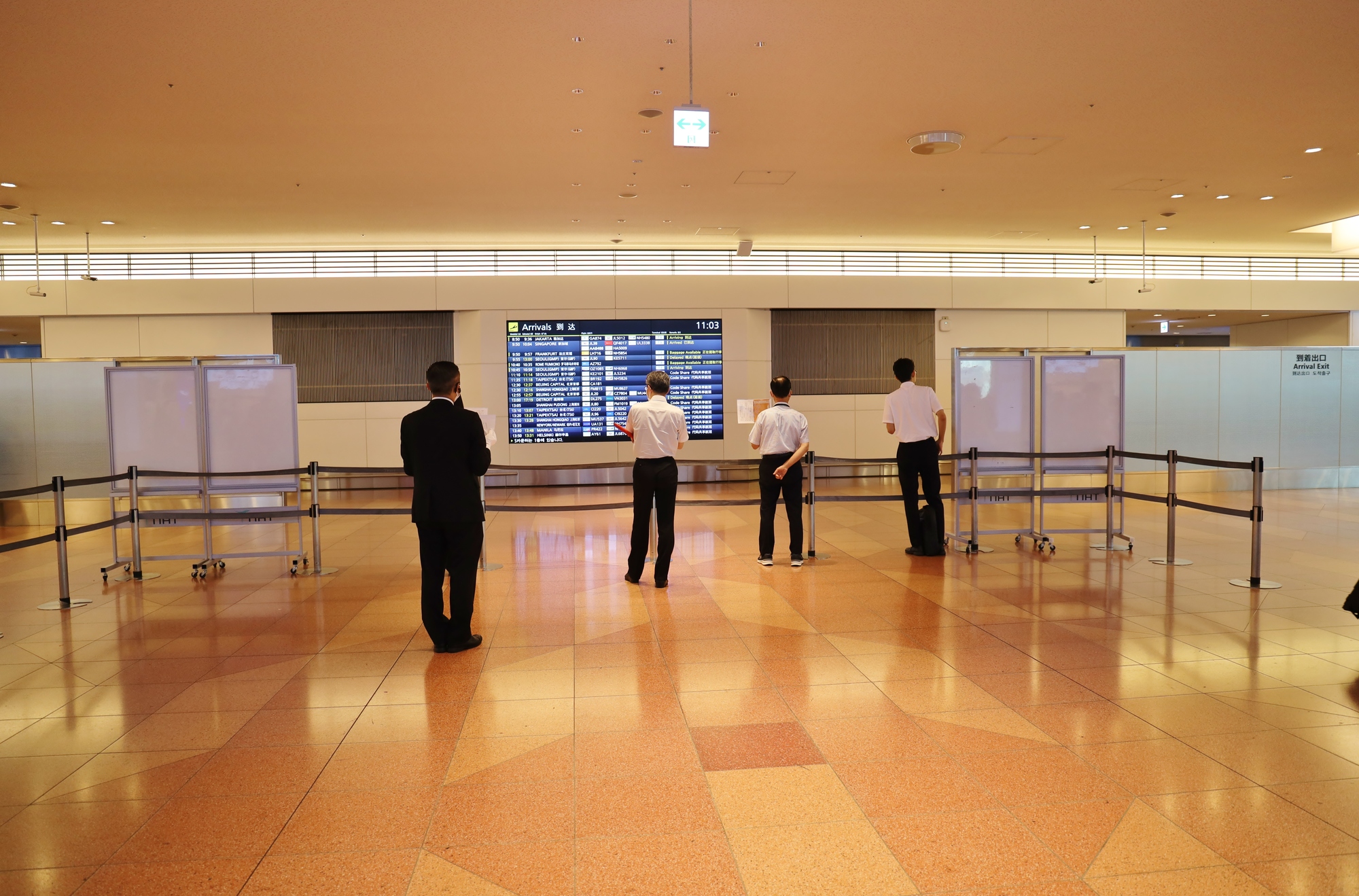 空港の国際線到着ロビーとフライト情報の表示板