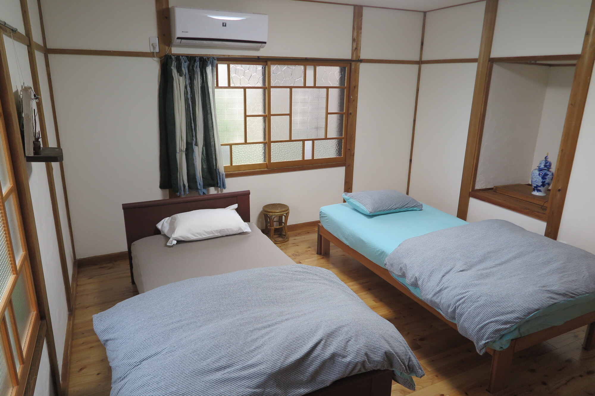 民泊として貸し出されている和室。布団と枕が整えられ、カーテンとエアコンのある部屋